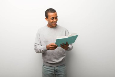 Bir kitap ve okuma zevk beyaz duvar arka plan üzerinde Afrika kökenli Amerikalı adam