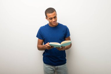 Bir kitap ve okuma zevk beyaz duvar genç Afro-Amerikan adam