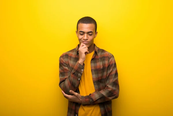 Giovane Uomo Afroamericano Sfondo Giallo Vibrante Guardando Basso Con Mano — Foto Stock