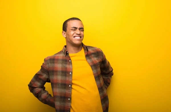 Giovane Uomo Afroamericano Uno Sfondo Giallo Vibrante Che Soffre Mal — Foto Stock