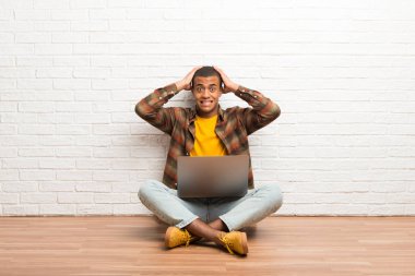 Afrika kökenli Amerikalı adam onun laptop alır zemin üzerinde ellerini kafasına çünkü oturan migren vardır