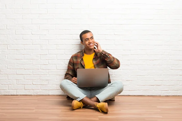 非洲裔美国人坐在地板上 他的笔记本电脑思考的想法 而抓头 — 图库照片