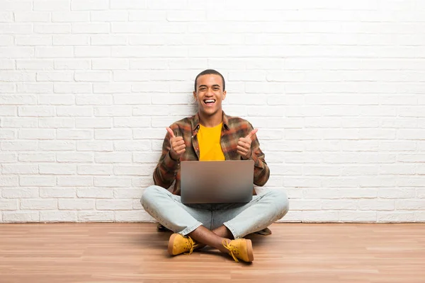 Hombre Afroamericano Sentado Suelo Con Portátil Dando Gesto Hacia Arriba — Foto de Stock