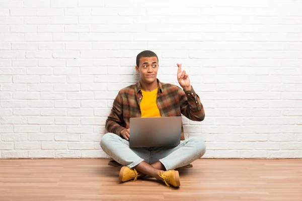 Hombre Afroamericano Sentado Suelo Con Portátil Con Los Dedos Cruzando — Foto de Stock