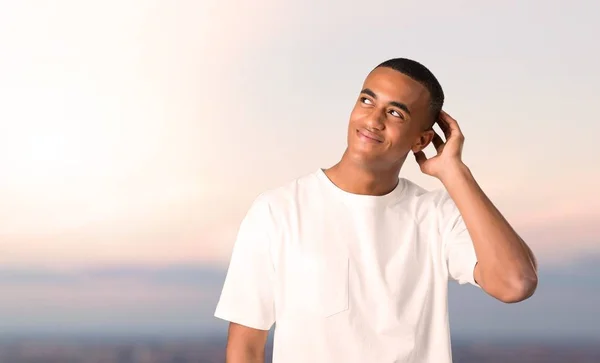 Молодий Афроамериканець Людиною Стоячи Мислення Уявлення Чухаючи Голову Тлі Заходу — стокове фото