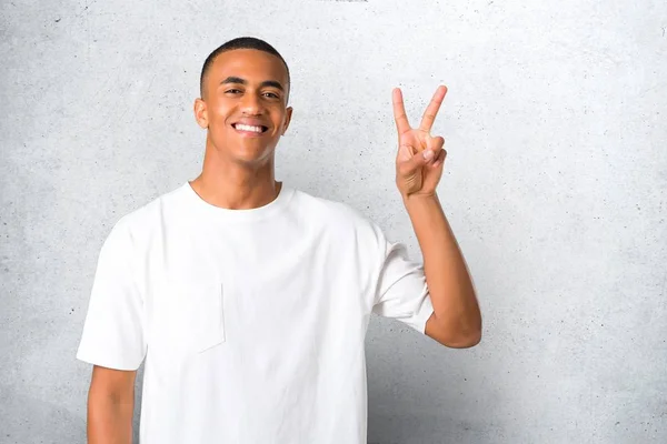 笑顔と陽気な顔に勝利のサインを示す若いアフリカ系アメリカ人の男 — ストック写真