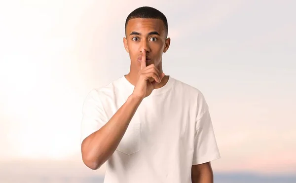 年轻的非洲裔美国男子表现出闭上嘴的标志和沉默的姿态 把手指在嘴上在日落背景 — 图库照片