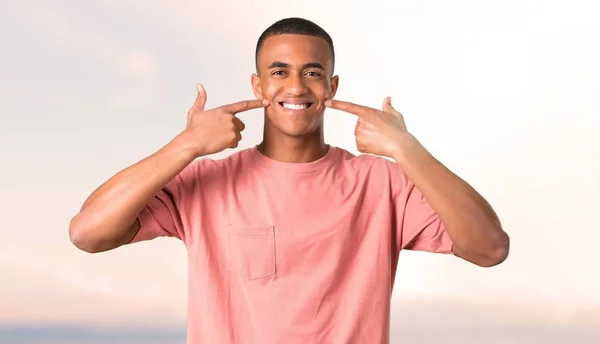 Темношкірий Чоловік Посміхається Щасливим Приємним Виразом Вказуючи Рот Обличчя Пальцями — стокове фото
