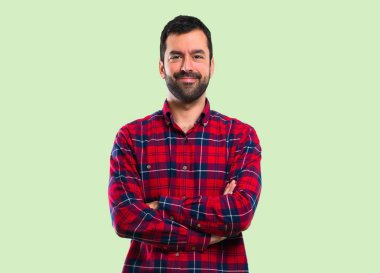 Silah tutmak yakışıklı yeşil arka plan üzerinde çarpı işareti