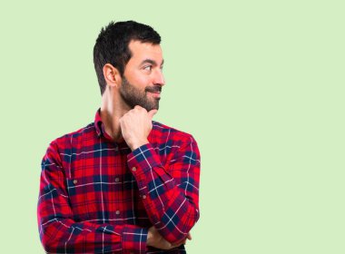 Ayakta ve yan üzerinde yeşil arka planı arıyorum yakışıklı adam