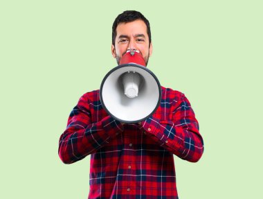 Yakışıklı adam üzerinden bir megafon yeşil zemin üzerine bağırarak