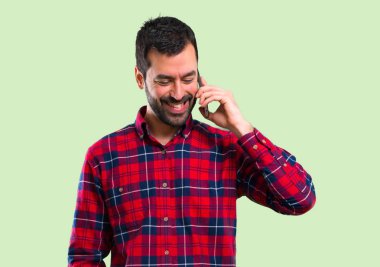 Yakışıklı adam cep telefonuyla yeşil arka plan üzerinde