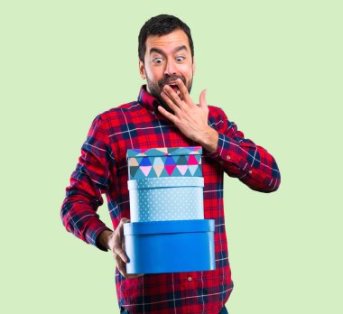 Yeşil arka plan üzerinde yakışıklı adam hediye kasa içi tutan eller