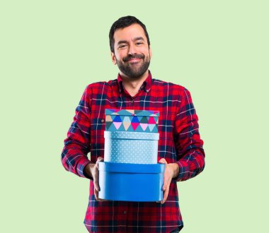 Yeşil arka plan üzerinde yakışıklı adam hediye kasa içi tutan eller