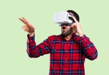 VR gözlük kullanan yakışıklı adam. Sanal gerçeklik deneyimi üzerinde yeşil arka plan