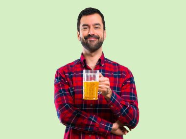 Yakışıklı adam yeşil arka plan üzerinde bira içmek