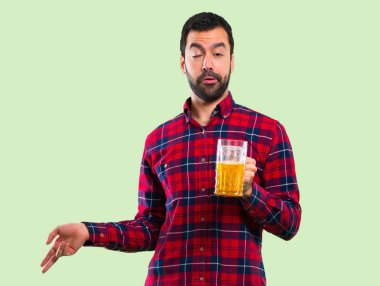 Yakışıklı adam yeşil arka plan üzerinde bira içmek