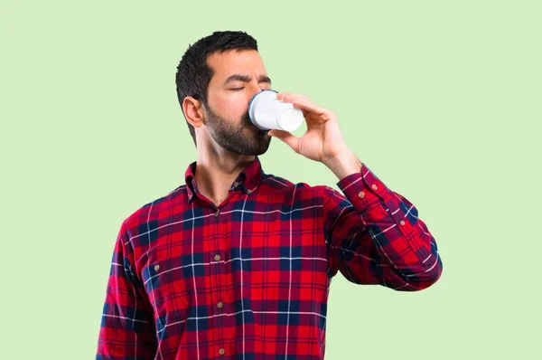 Knappe Man Met Warme Koffie Afhaalmaaltijden Papier Cup Groene Achtergrond — Stockfoto