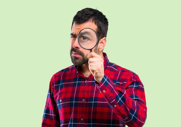 Bonito Homem Segurando Uma Lupa Fundo Verde — Fotografia de Stock