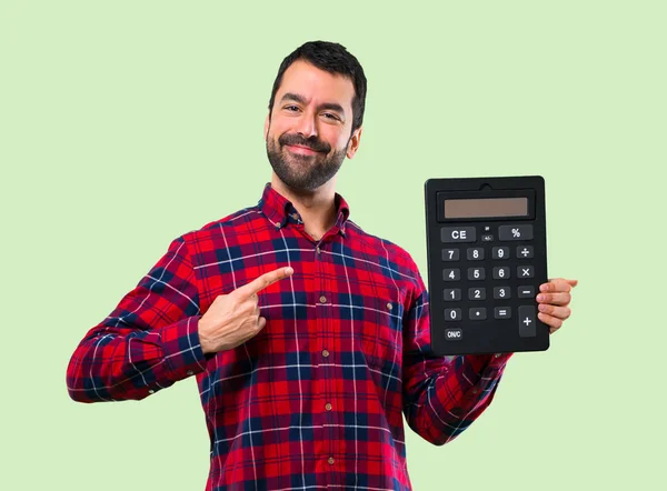 Красивый Мужчина Калькулятором Подсчет Машины Зеленом Фоне — стоковое фото