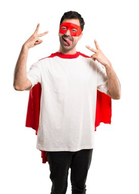 Süper kahraman maske ve kırmızı pelerin komik göz izole beyaz arka plan üzerinde olan kamera dilini gösteren adamla