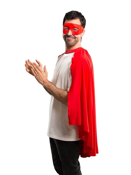 Superhero man with mask and red cape applauding after presentation in a conference on isolated white background