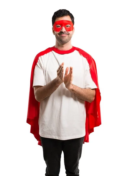 Superhero man with mask and red cape applauding after presentation in a conference on isolated white background