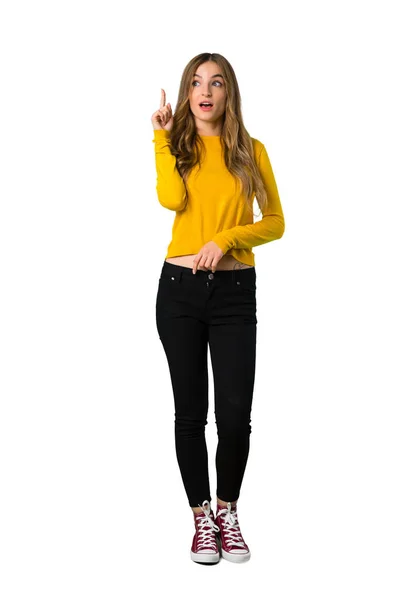 一个穿着黄色毛衣的年轻女孩的全长照片 她想着一个想法 把手指指向孤立的白色背景 — 图库照片
