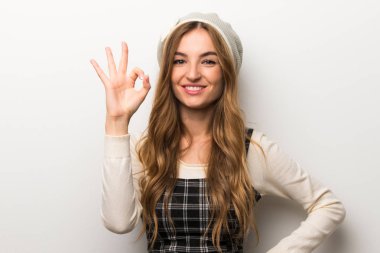 Zarif şekilde parmak ok işaretiyle gösterilen şapka giyen kadın