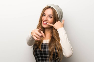 Modaya uygun telefon jest yapma ve açık işaret şapka giyen kadın