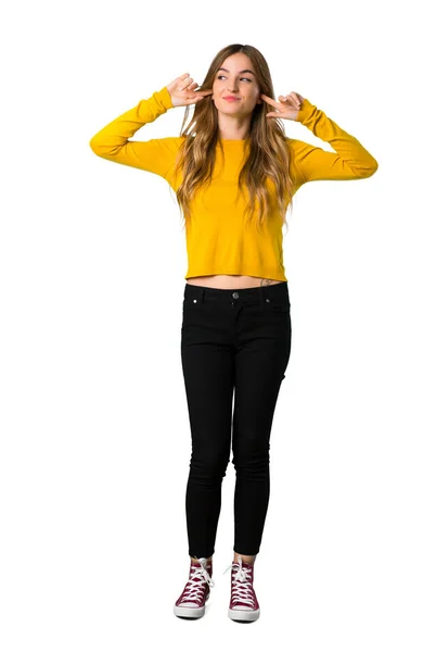 Повнометражний Знімок Молодої Дівчини Жовтим Светром Покриває Обидва Вуха Руками — стокове фото