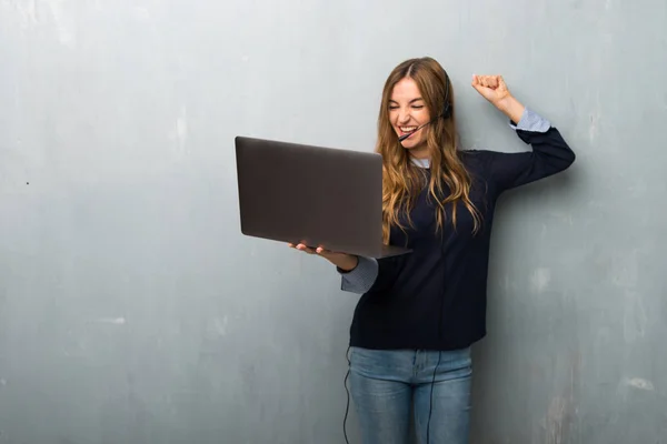 Telemarketer woman with laptop and celebrating a victory