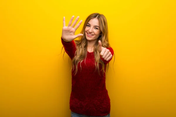 年轻女孩在充满活力的黄色背景计数六用手指 — 图库照片