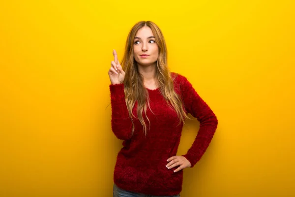 Menina Fundo Amarelo Vibrante Com Dedos Cruzando Desejando Melhor — Fotografia de Stock