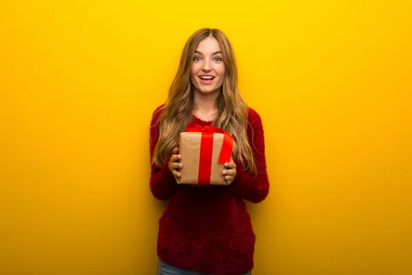 Chica Joven Sobre Fondo Amarillo Vibrante Sorprendido Porque Dado Regalo —  Fotos de Stock