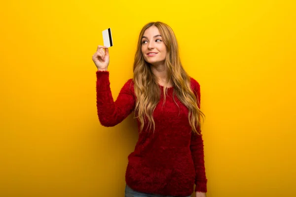 Menina Fundo Amarelo Vibrante Segurando Cartão Crédito Pensando — Fotografia de Stock