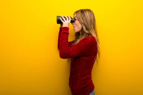 Mladá Dívka Pulzující Žlutým Pozadím Dálce Při Pohledu Dalekohledem — Stock fotografie