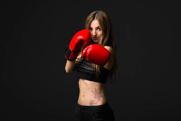 暗い背景にボクシング グローブを持つスポーツ女性 — ストック写真