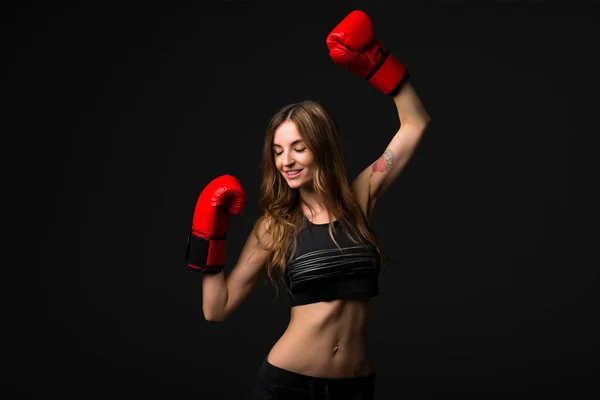 运动女子与拳击手套在黑暗的背景 — 图库照片