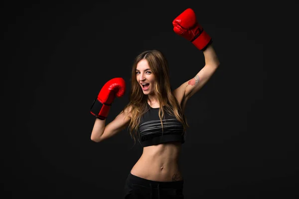 暗い背景にボクシング グローブを持つスポーツ女性 — ストック写真