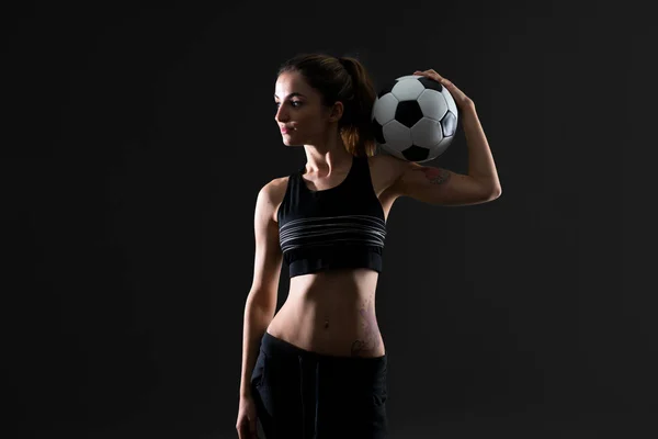 サッカー ボールを保持している暗い背景にスポーツの女性 — ストック写真