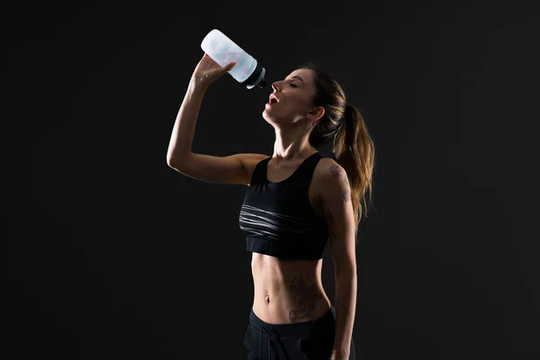 Mujer Deportiva Con Una Botella Agua Sobre Fondo Oscuro —  Fotos de Stock