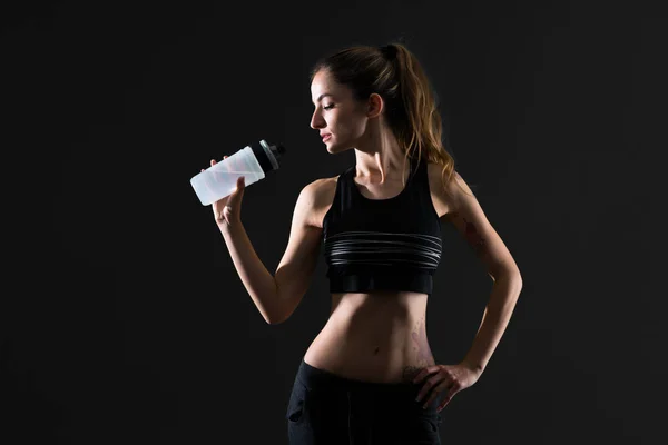 Donna Sportiva Con Una Bottiglia Acqua Sfondo Scuro — Foto Stock