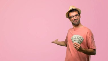 Geri işaret ve pembe bir ürün sunma faturaları tutan adam