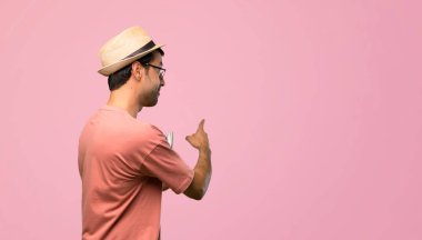 Faturaları geri pembe bir arka plan üzerinde işaret parmağı ile işaret tutan adam