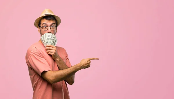 Człowiek Posiadający Wiele Ustaw Wskazując Palcem Bok Zdziwieniem Różowym Tle — Zdjęcie stockowe