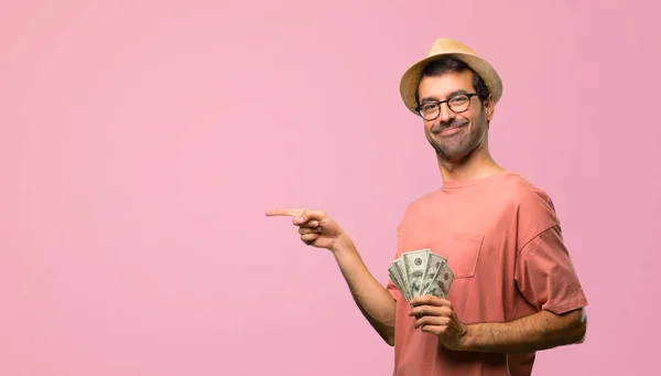 Man Holding Many Bills Pointing Finger Side Lateral Position Pink — Stock Photo, Image