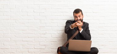 Birisi parmak ile işaret ve gülerek yere oturma onun laptop ile işadamı