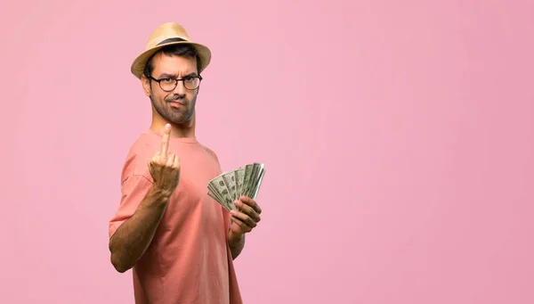 Człowiek Posiadający Wiele Rachunki Podejmowania Gest Róg Różowym Tle — Zdjęcie stockowe