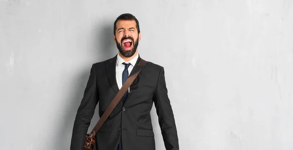 Businessman with beard shouting to the front with mouth wide open
